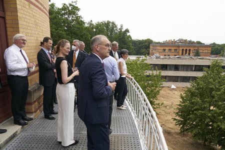 Several persons standing on a balcony and looking far ahead