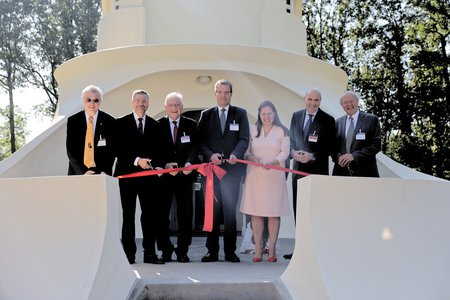 Seven persons stand with scissors behind a red ribbon on the terrace of the Einstein Tower.