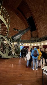 People in a dome next to a telescope