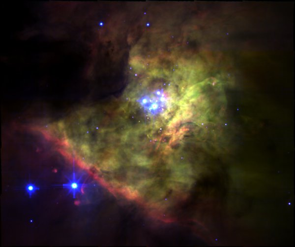 The Orion Nebula showing green/red ionized gas and blue stars