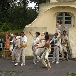 Einige Personen in weißer Kleidung tanzen vor dem Einsteinturm