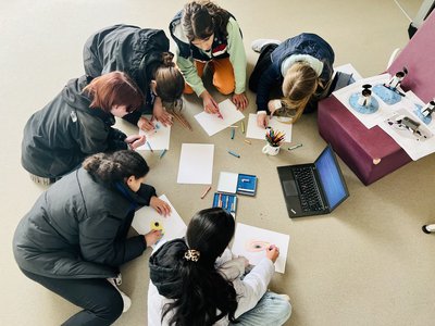 Girls sitting in a circle, drawing something