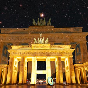 Bildkomposition: Brandenburger Tor vor einem Sternenhimmel mit einer 0, die an einem hervorgehobenen "H" des Tors lehnt.