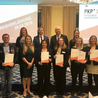 Group photo of the winners holding their certificates with the Mayor of Potsdam and staff of the Congress Award.