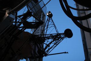 Part of the teleskope and the dark blue sky in the background