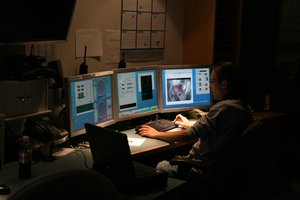 A person in a dark room with monitors