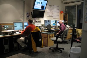 Two persons at desktops with monitors