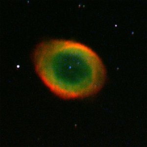 Photograph of a ring-shaped nebula with green centre and red outer ring